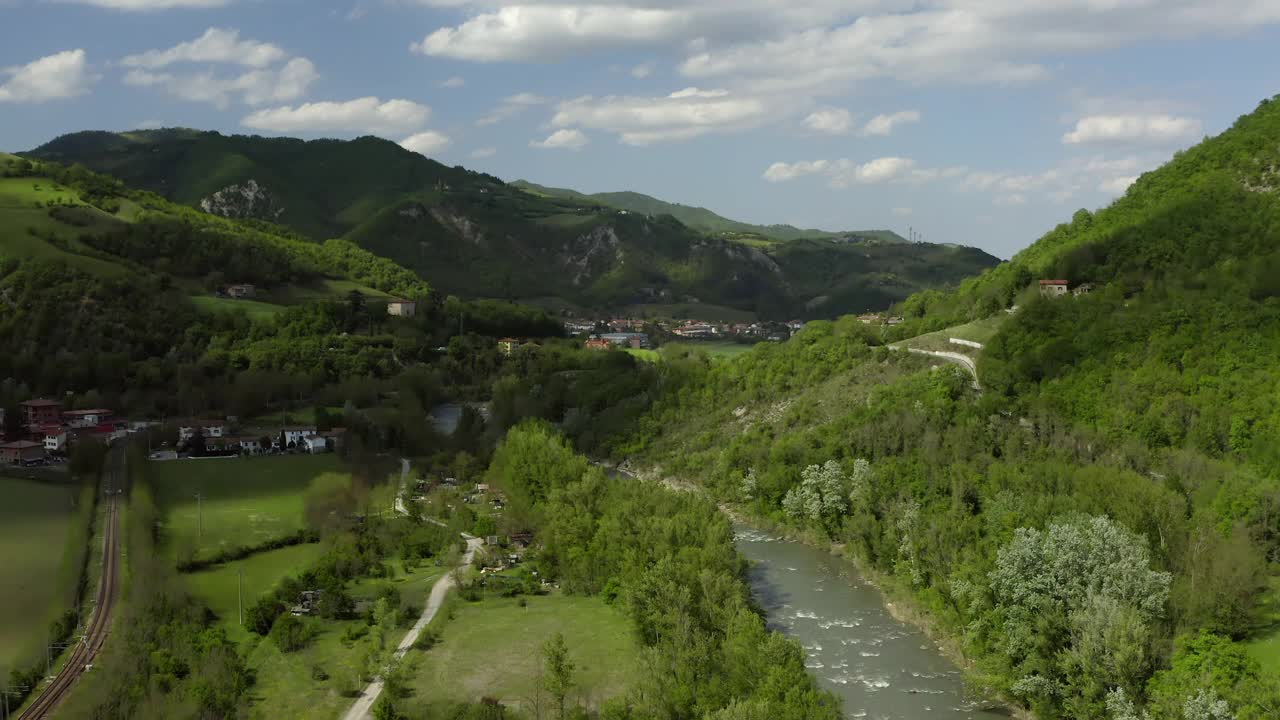 在山上的住宅的空中风景，无人机在阳光下飞过河流-亚平宁山脉，意大利视频素材