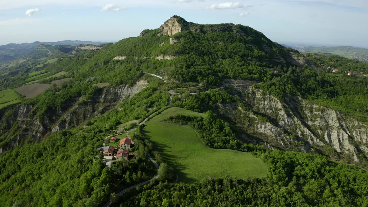 云天下的山上绿色景观上的建筑鸟瞰图-意大利亚平宁山脉视频素材