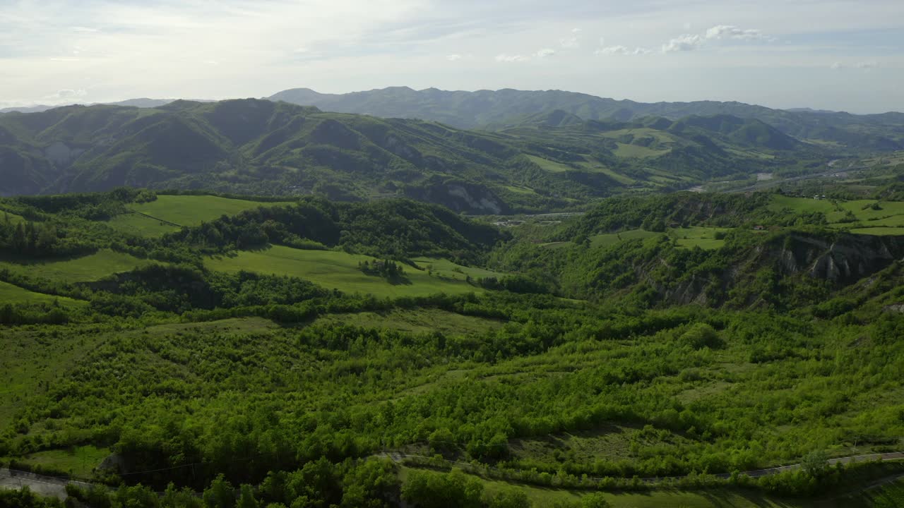 空中田园景色的天然小山对多云的天空，无人机飞行向前在绿色景观-亚平宁山脉，意大利视频素材