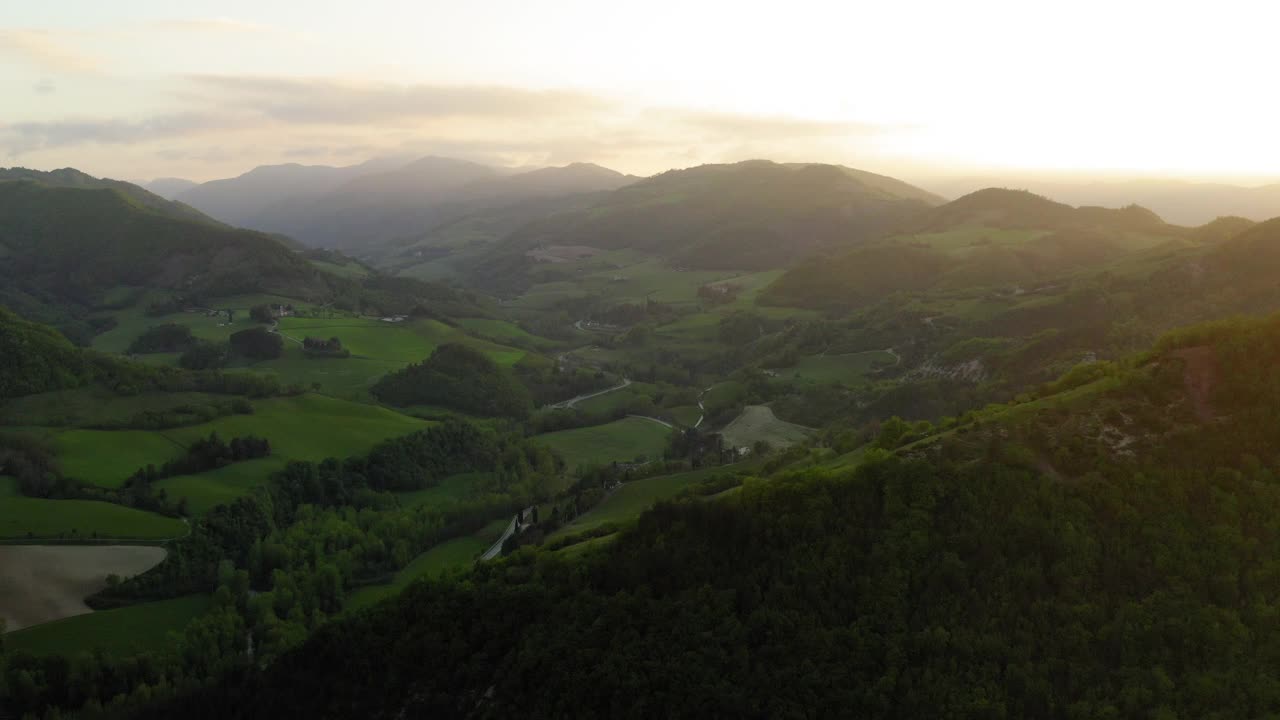 日落时的天然山丘的空中风景，无人机在风景上的绿树上飞行-亚平宁山脉，意大利视频素材