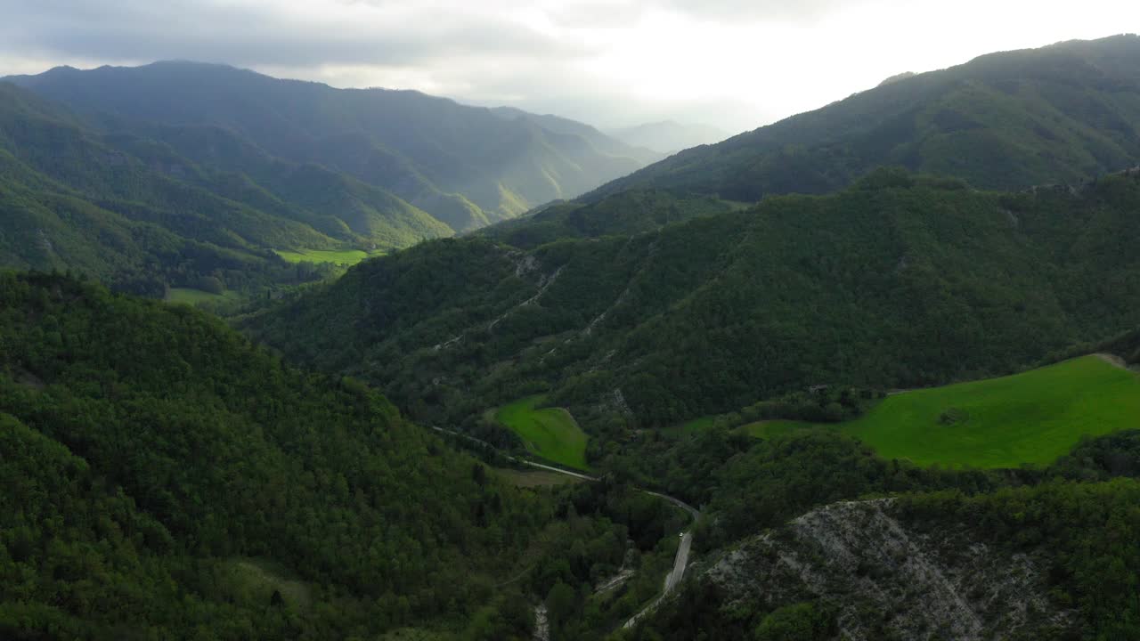 空中前进风景拍摄的道路在山，无人机飞越森林-亚平宁山脉，意大利视频素材