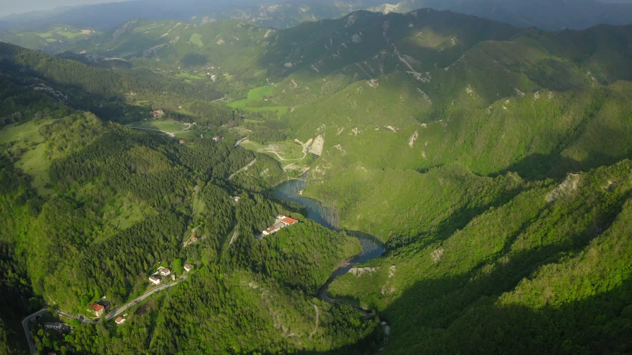 在山上的住宅的空中美丽的镜头，无人机向后飞行在绿色森林-亚平宁山脉，意大利视频素材