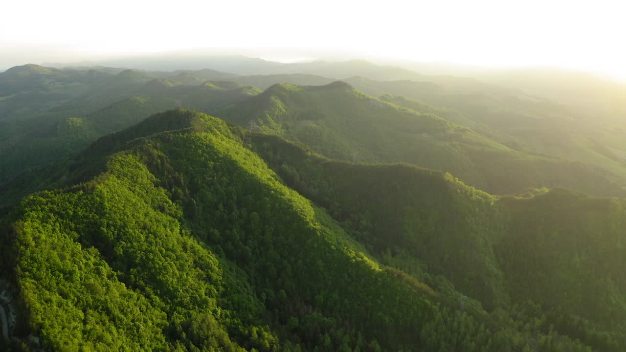 空中亚平宁山对多云的天空，无人机飞行G向前越过绿色森林视频素材