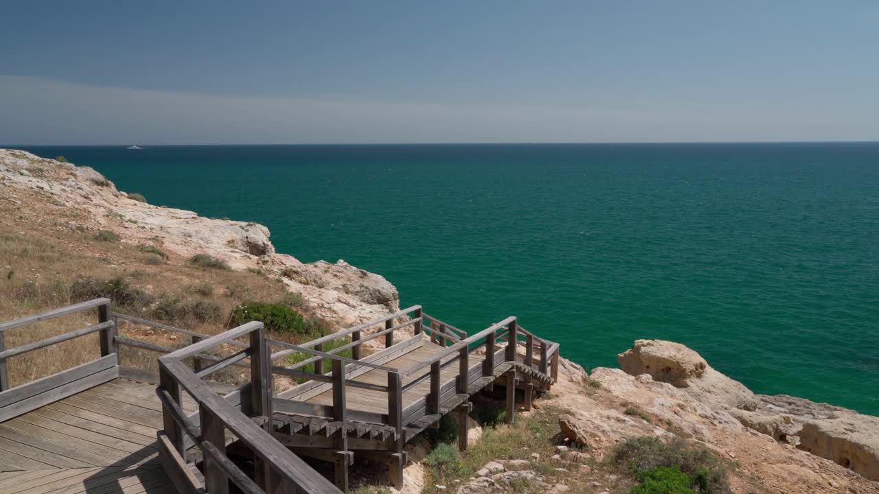 沿着木路散步，你会看到夏天葡萄牙卡沃埃罗海岸的美妙景色。俯瞰蓝色的大海。用稳定器在运动中射击。视频素材