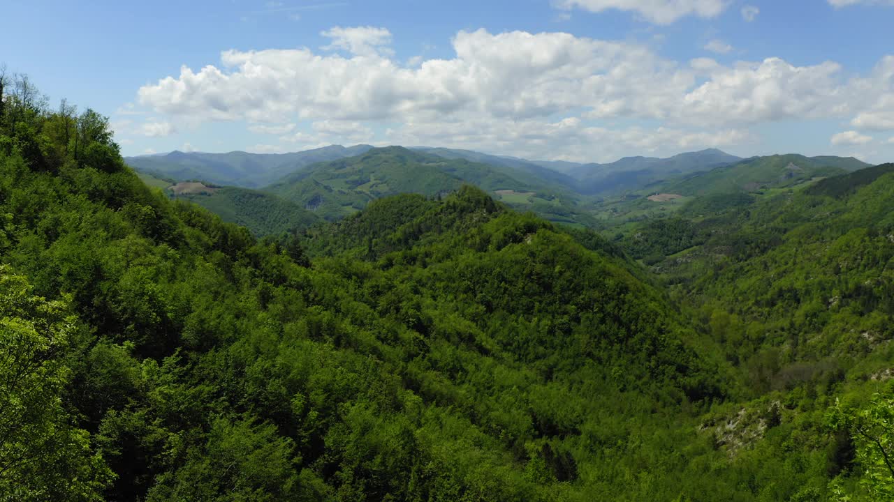 空中:在多云的天空下的绿色山脉的风景，无人机向后飞行在绿色景观-亚平宁山脉，意大利视频素材