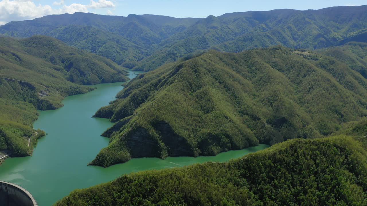 在湖里的绿色山脉的空中风景，无人机在阳光明媚的日子飞行-亚平宁山脉，意大利视频素材