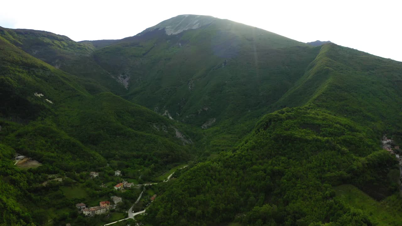 空中风景拍摄的房子在山上，无人机飞行向前在绿色景观-亚平宁山脉，意大利视频素材