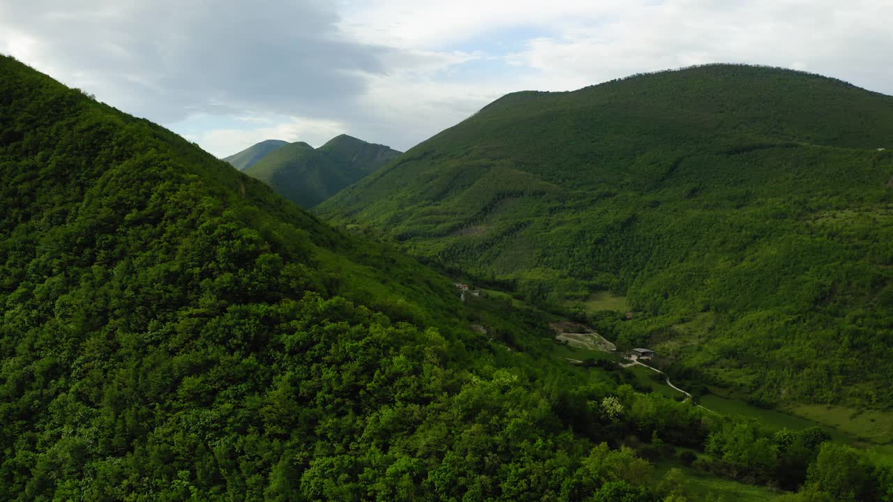 航拍:小山中的建筑，无人机向后飞过绿色植物-亚平宁山脉，意大利视频素材