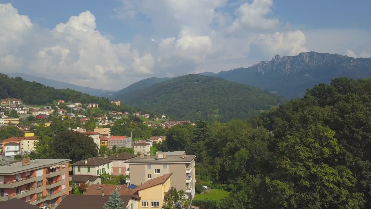 在一个阳光明媚的日子，无人机拍摄了一个身后有起伏山丘的山村视频素材