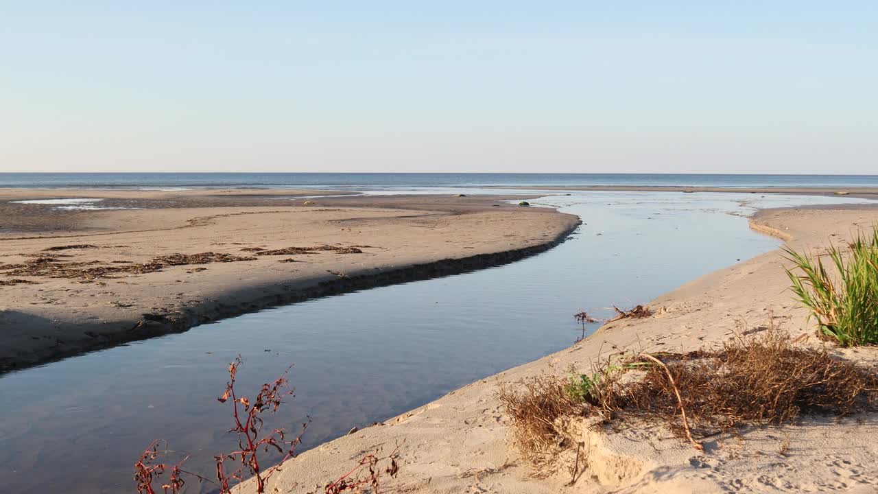 河流平静而缓慢地流向沙质的波罗的海海岸线，形成一个三角洲视频素材