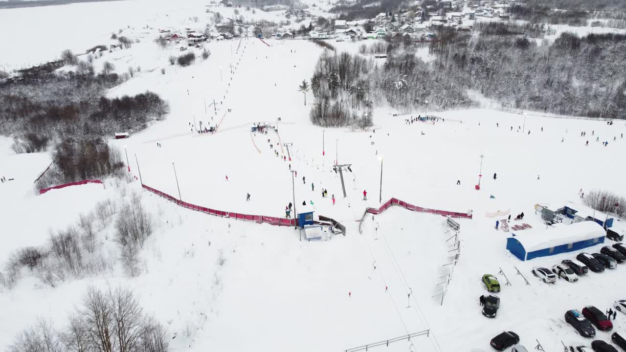 在滑雪胜地，无人机在索道上的全景俯视图。滑雪电梯运送滑雪者和滑雪板运动员在雪山度假村的冬季斜坡上，许多人。UHD 4 k的视频视频素材