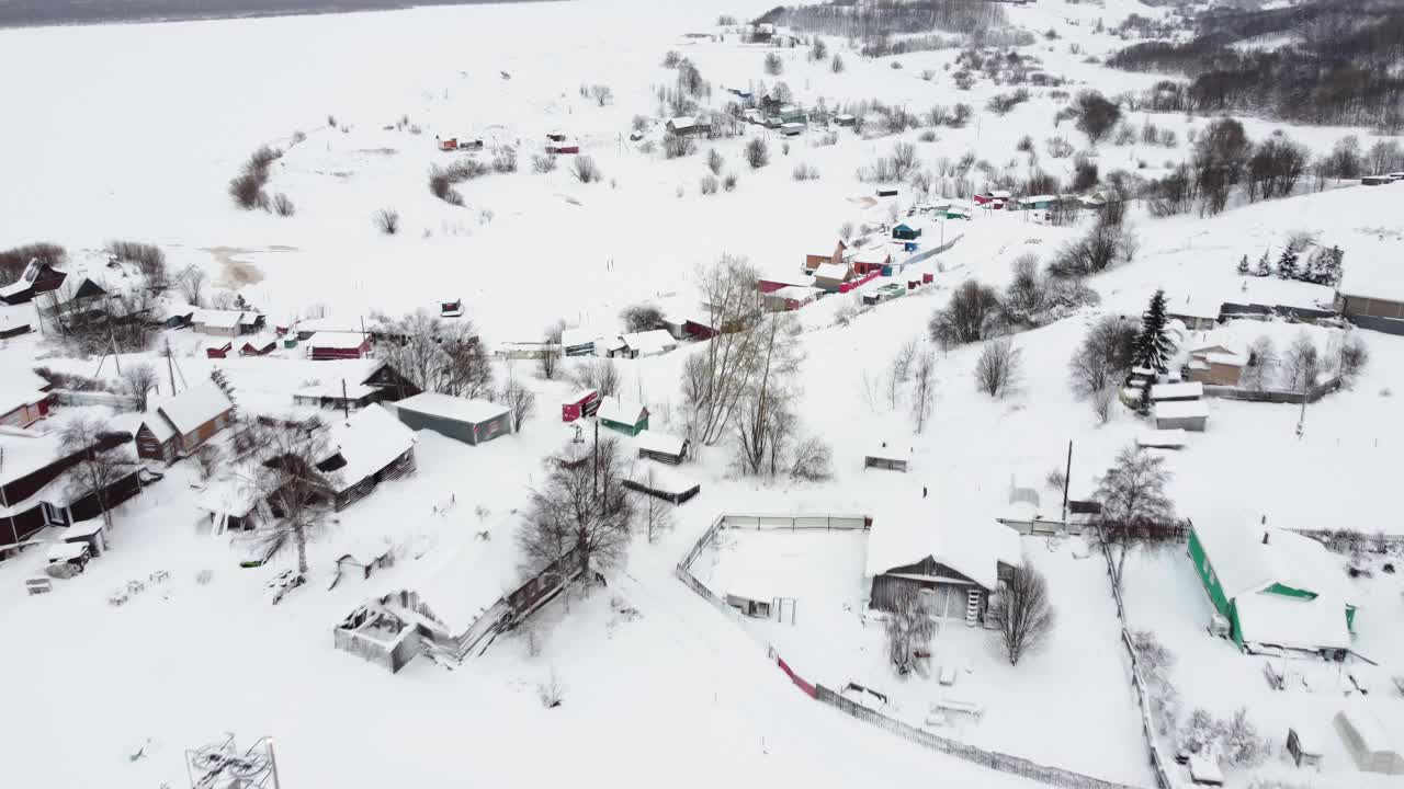 从无人机鸟瞰的一个小村庄，冬天的风景，霜天，一切都被雪覆盖视频素材