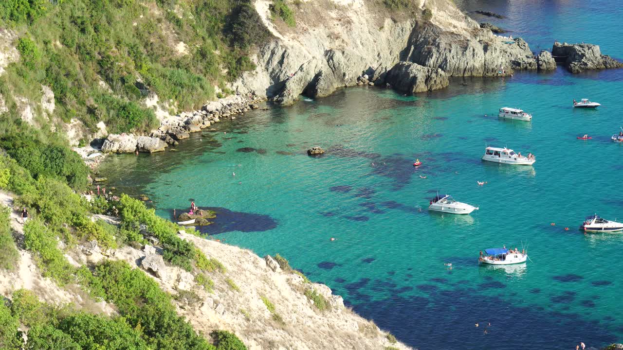 小船和游艇在蔚蓝的大海上。鸟瞰图的山脉和岩石的海景。未开发的自然，干净的水。岩石海岸和隐藏的海滩。夏季旅游和休息的理想场所视频素材