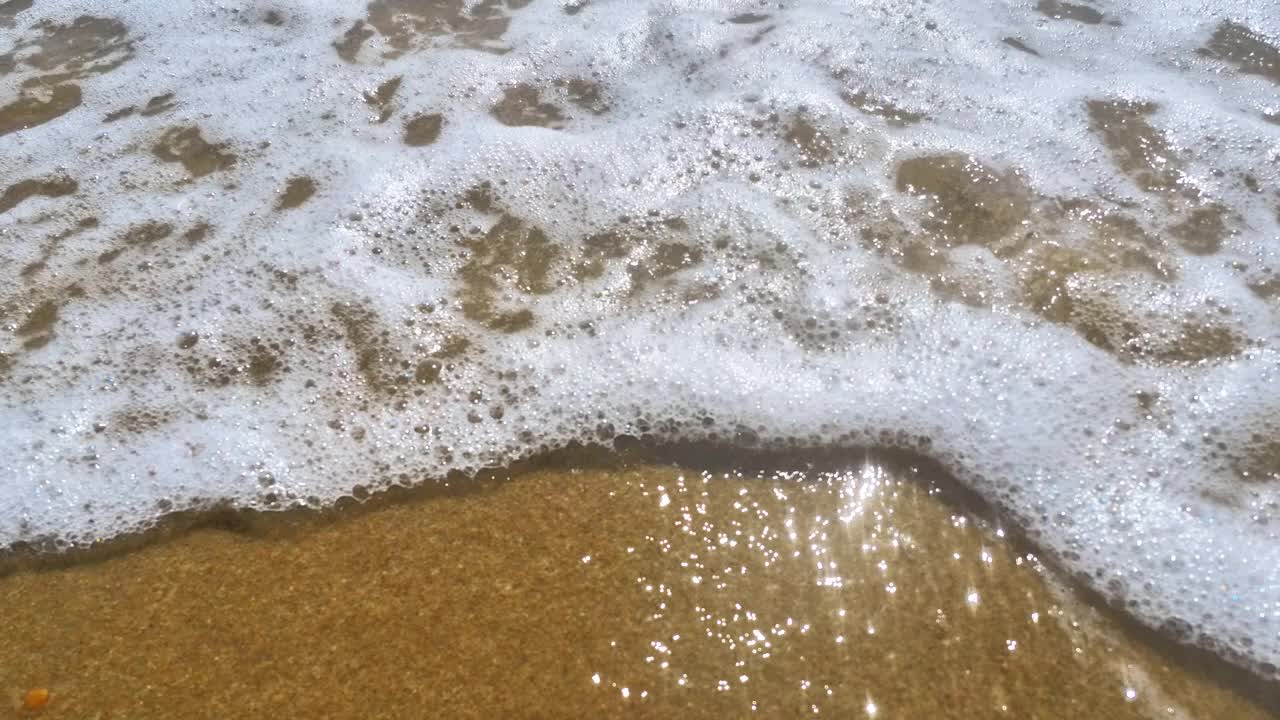 海浪卷上白色沙滩的特写镜头视频素材