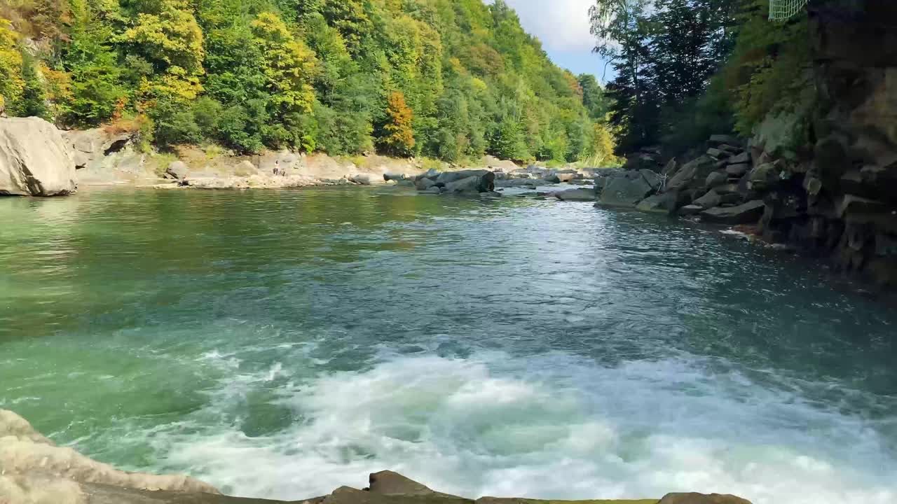 在乌克兰喀尔巴阡山脉，秋天的山河在美丽的森林中流淌。自然和旅游的概念视频素材