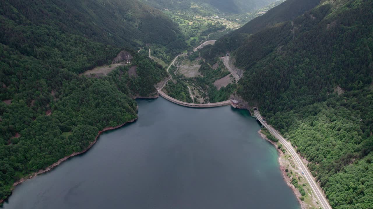 在高山上的一个巨大的防洪坝。美丽的景色，巨大的建筑结构，筑坝蓄水。视频素材