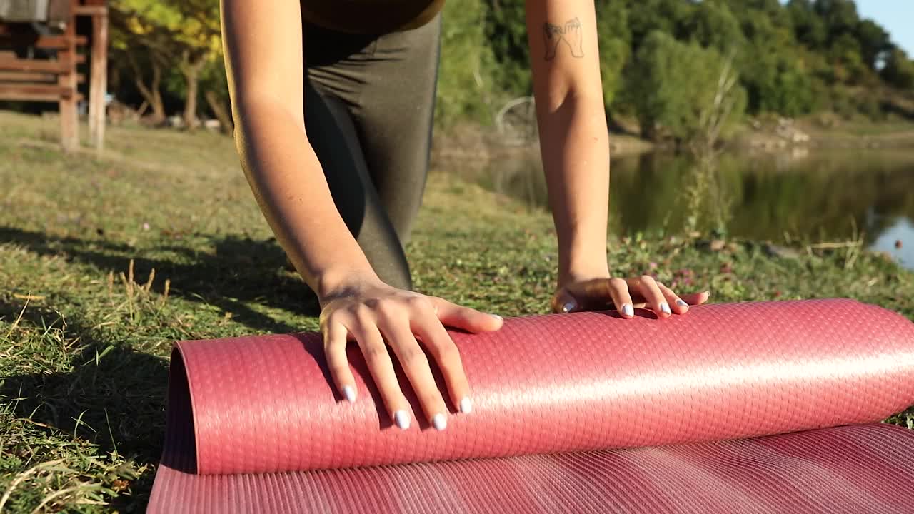 一名女子在练习瑜伽后，将手放在瑜伽垫上的慢动作视频素材