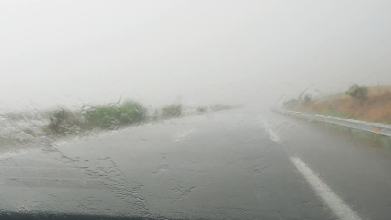 车的观点行驶在下雨的公路和挡风玻璃雨刷擦雨视频素材