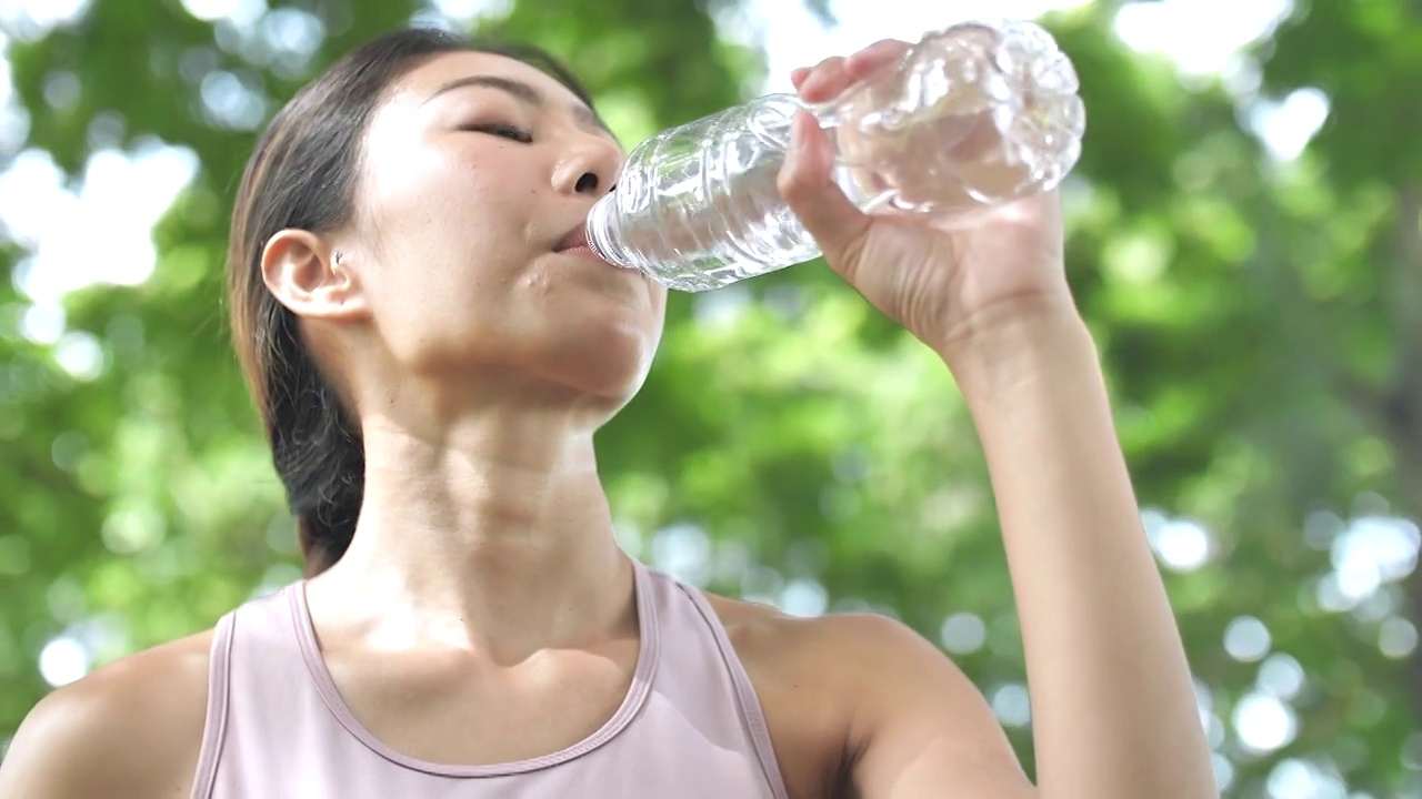 亚洲健身女子跑步后喝水视频素材