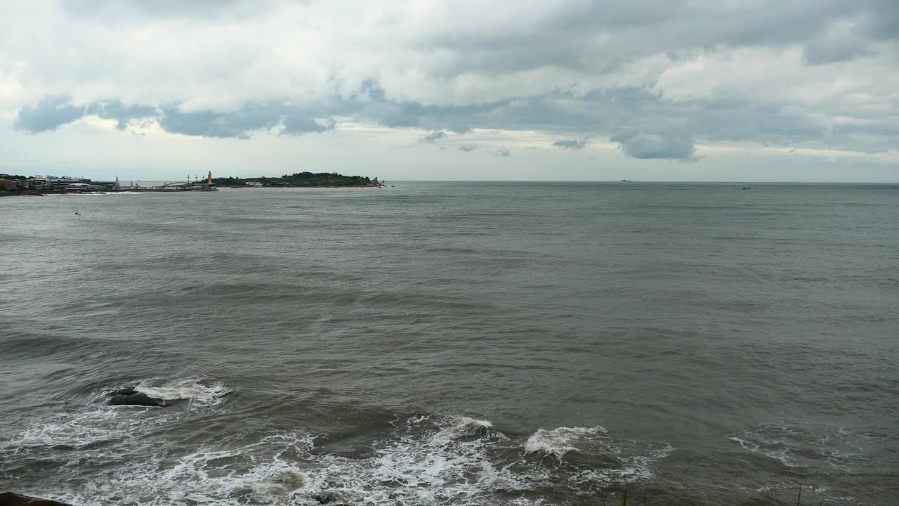 4k波光粼粼的海洋海水海浪表面和海岸岩石海岸云朵云景。视频素材