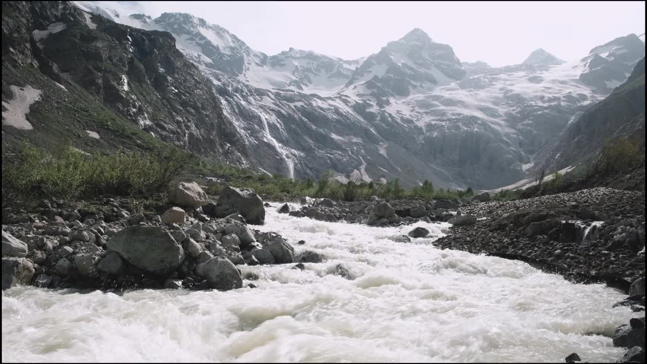 湍急的山河在岩石间流动。山上的雪和冰川视频素材