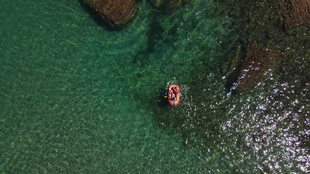 鸟瞰图的成年男人和女人在海上水面的橡皮艇上游泳，女人和男人在一个充气皮艇上，男人和女人划着一个充气水船，体育，旅游，旅游视频素材