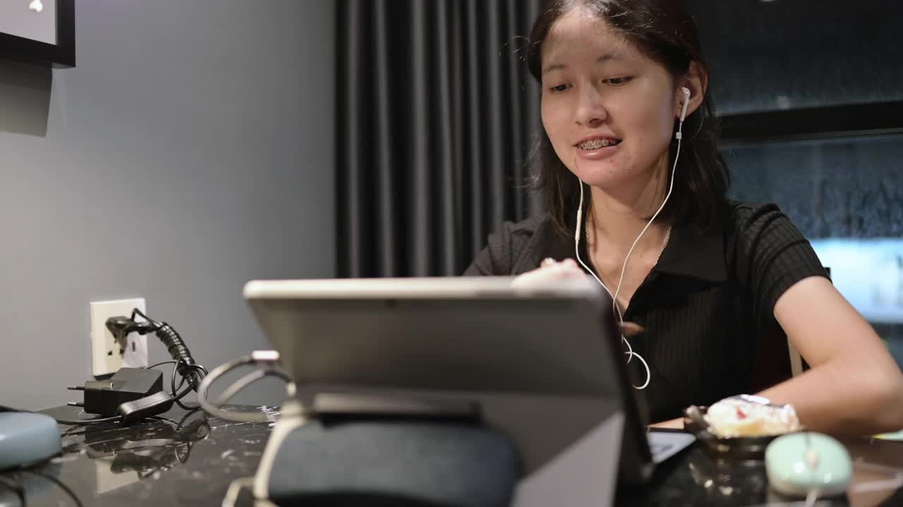 亚洲妇女在线学习教育，学习自我提升技能概念，吃草莓芝士蛋糕视频素材