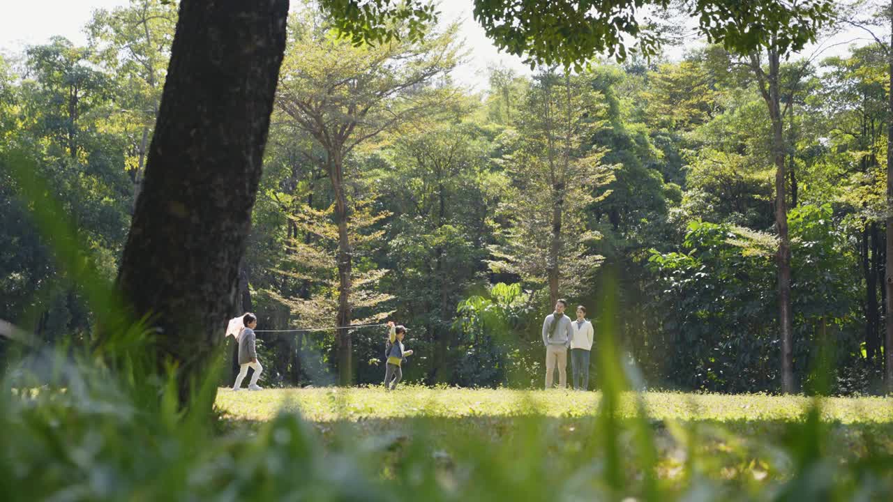 亚洲家庭在公园户外放风筝视频素材