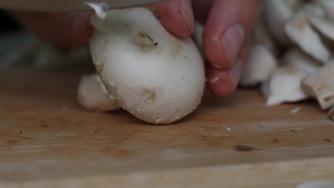 特写男子切割冠军木制切板。饮食健康饮食。特写男手在木板上用刀切香菇。素食健康食品。饮食健康的生活方式。视频素材