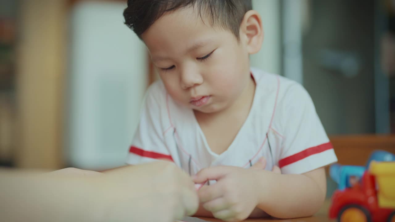 在新冠肺炎疫情期间，为了防止细菌传播，男婴们在客厅里用彩色笔画画。照顾孩子。视频素材