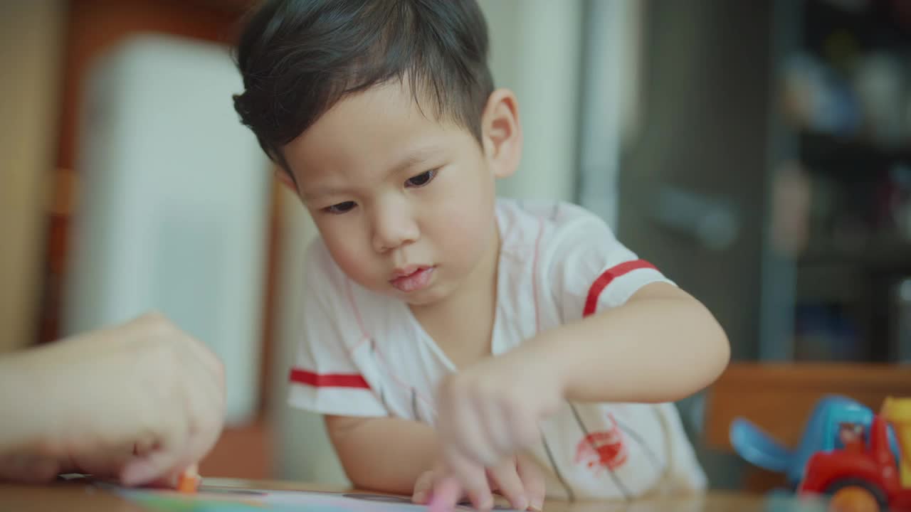 在新冠肺炎疫情期间，为了防止细菌传播，男婴们在客厅里用彩色笔画画。照顾孩子。视频素材