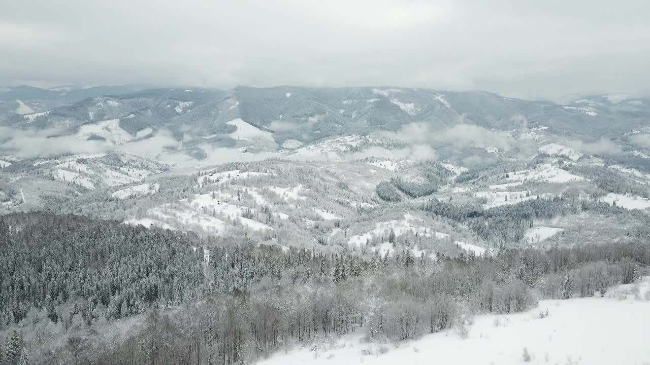 从童话般的高山景观上看，白雪覆盖着阿尔卑斯的尖峰。乌克兰喀尔巴阡山脉的寒冬。厚厚的白云。开放空间。空中4 k视频素材