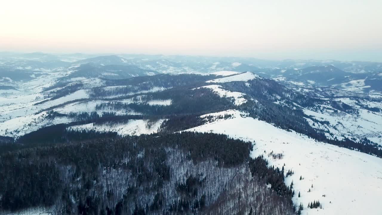 从童话般的高山景观上看，白雪覆盖着阿尔卑斯的尖峰。乌克兰喀尔巴阡山脉的寒冬。厚厚的白云。开放空间。空中4 k视频素材