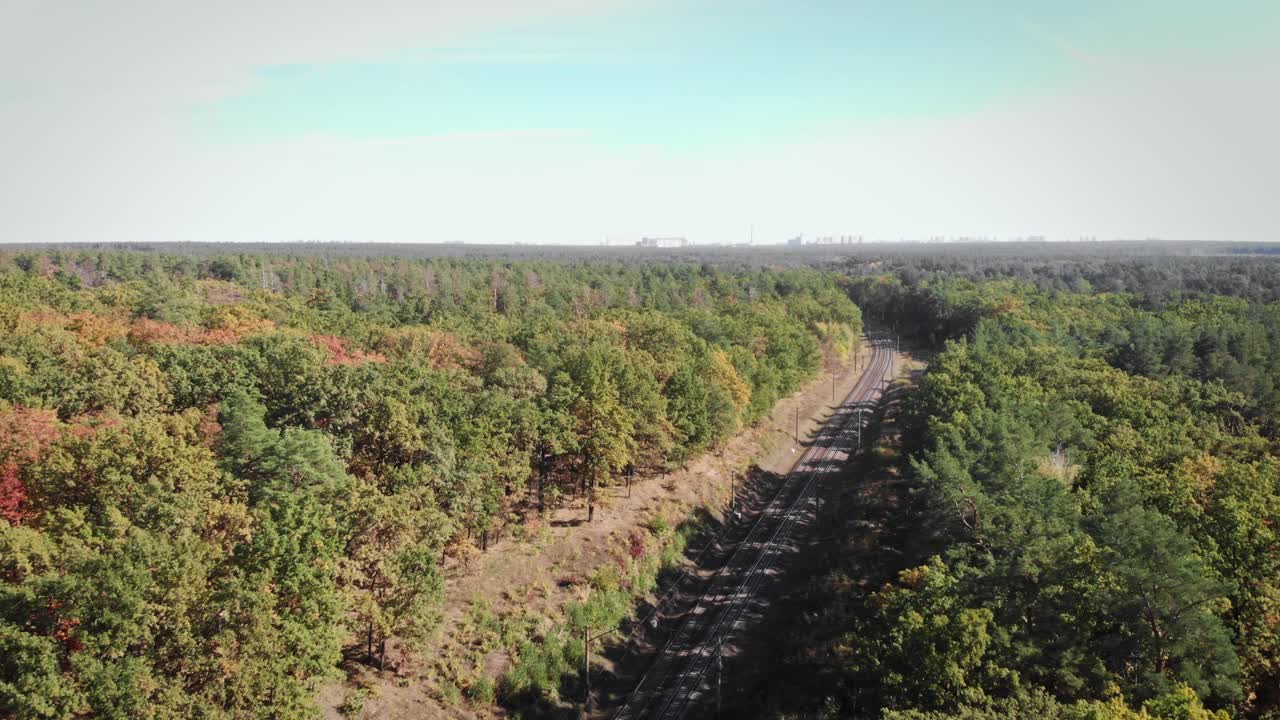 美丽的森林背景，蓝天和空旷的铁路公路。铁轨和铁路枕木，高压电线。运输的概念视频素材