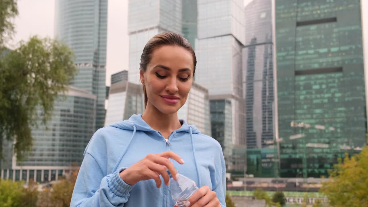 活跃的女人在训练休息时喝水瓶的肖像视频素材