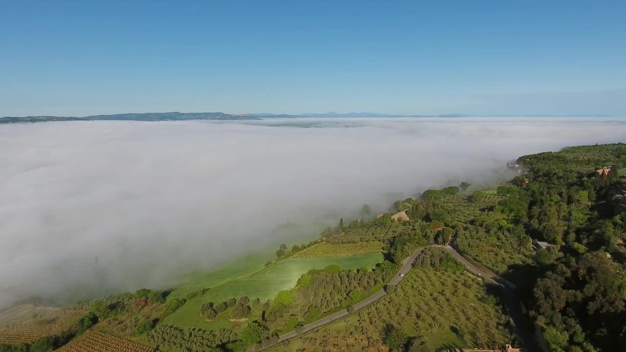 大雾笼罩在托斯卡纳山区的农田上。空中视频素材