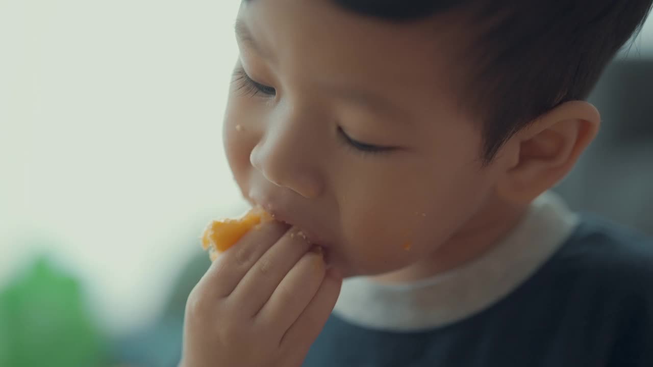 喜欢吃橙子蛋糕的孩子男孩，天在一个孩子的生活。视频素材