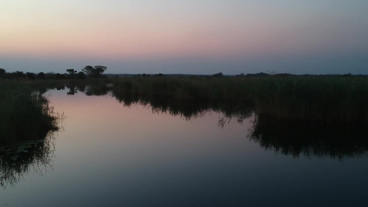 深蓝色和紫色的日落俯瞰宽岛河和湿地，相机右移，让河流航拍视频视频素材