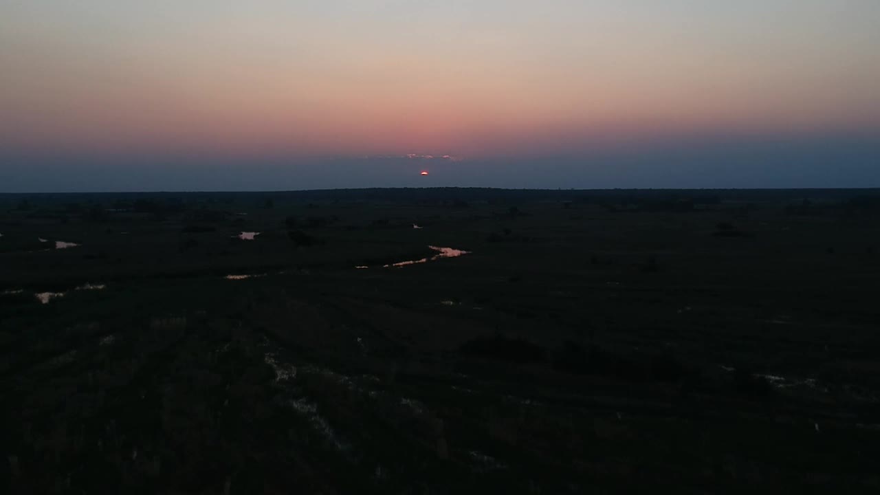 深红色的日落在莞岛河上，红色的太阳倒映在河水上，周围都是湿地视频素材