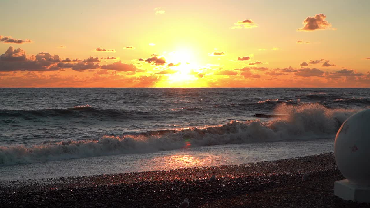 海浪滔天的海洋海滩，云雾缭绕的橙色天空。海景和海岸。自然,景观,海景。旅游,度假,度假视频素材