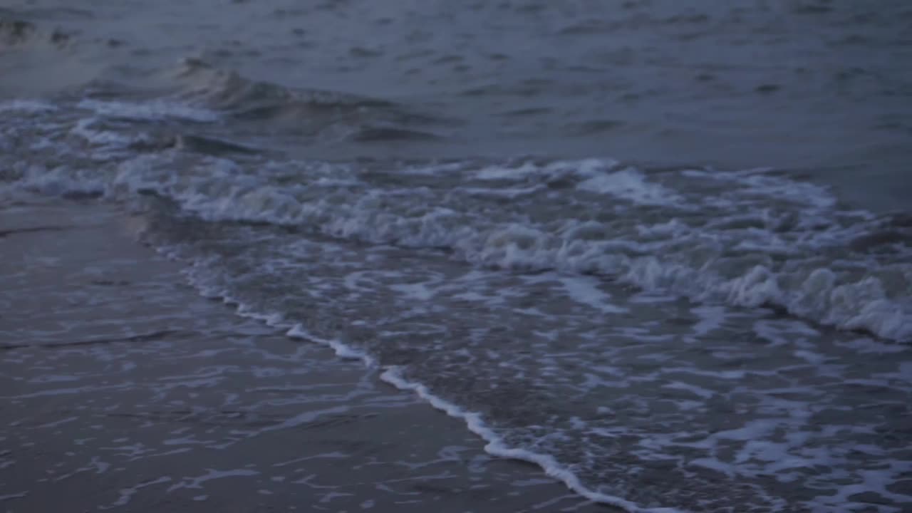 海浪冲刷着沙滩。日落时海滩会掀起波浪。视频素材