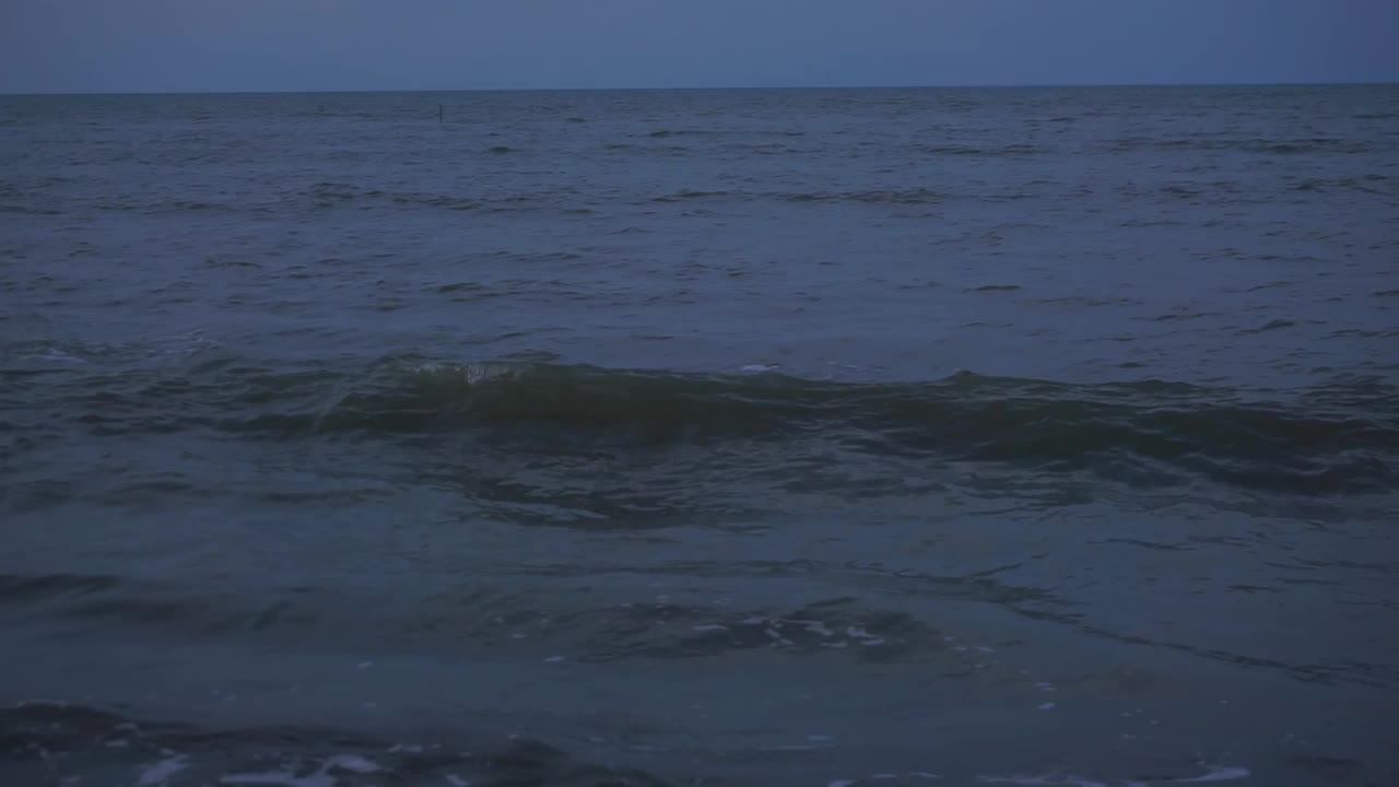 海浪冲刷着沙滩。日落时海滩会掀起波浪。视频素材