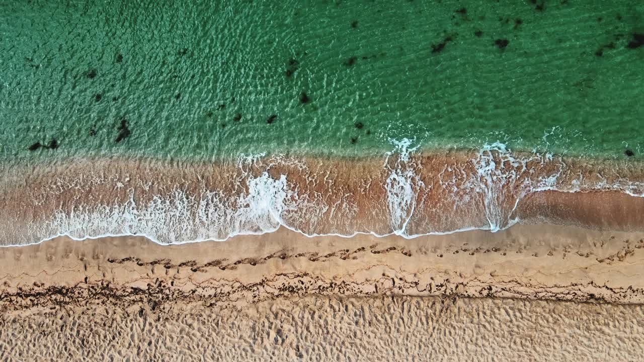 在海浪和白色沙滩上的空中顶部无人机视图。水晶水景观视频素材