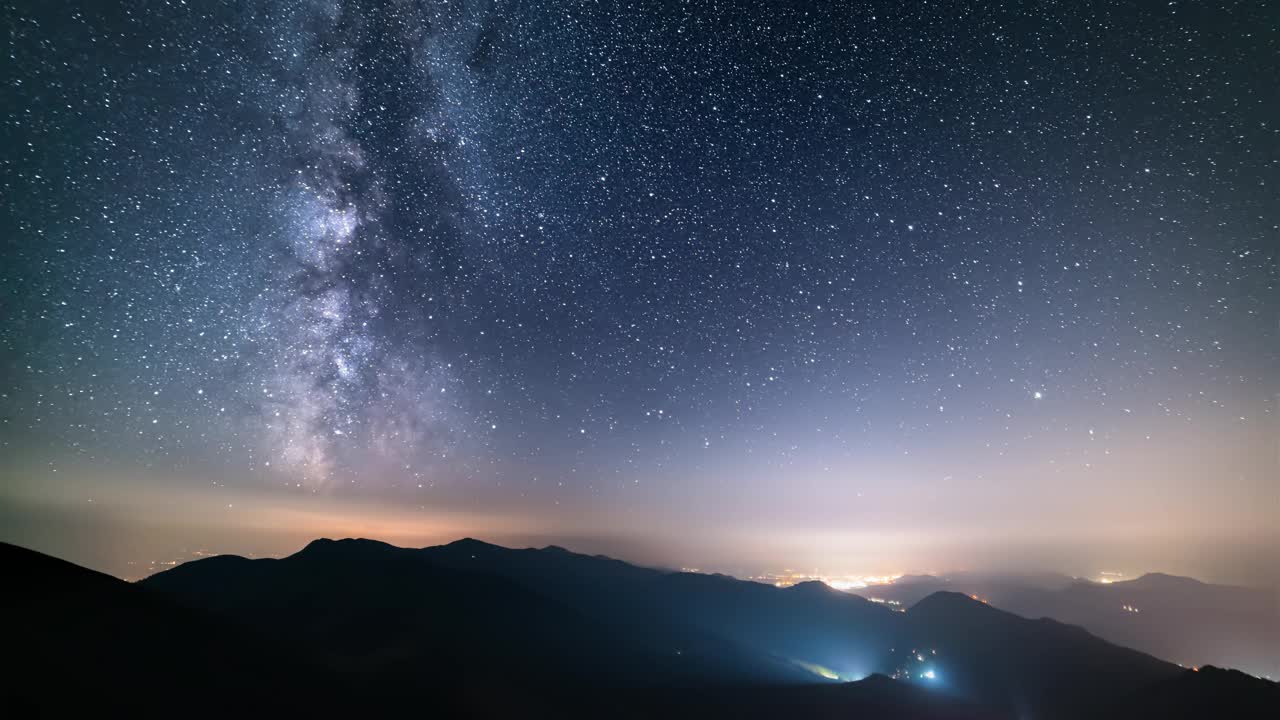 繁星点点的夜空在山间天文时光流逝，银河的星星在乡村的交通上移动视频素材