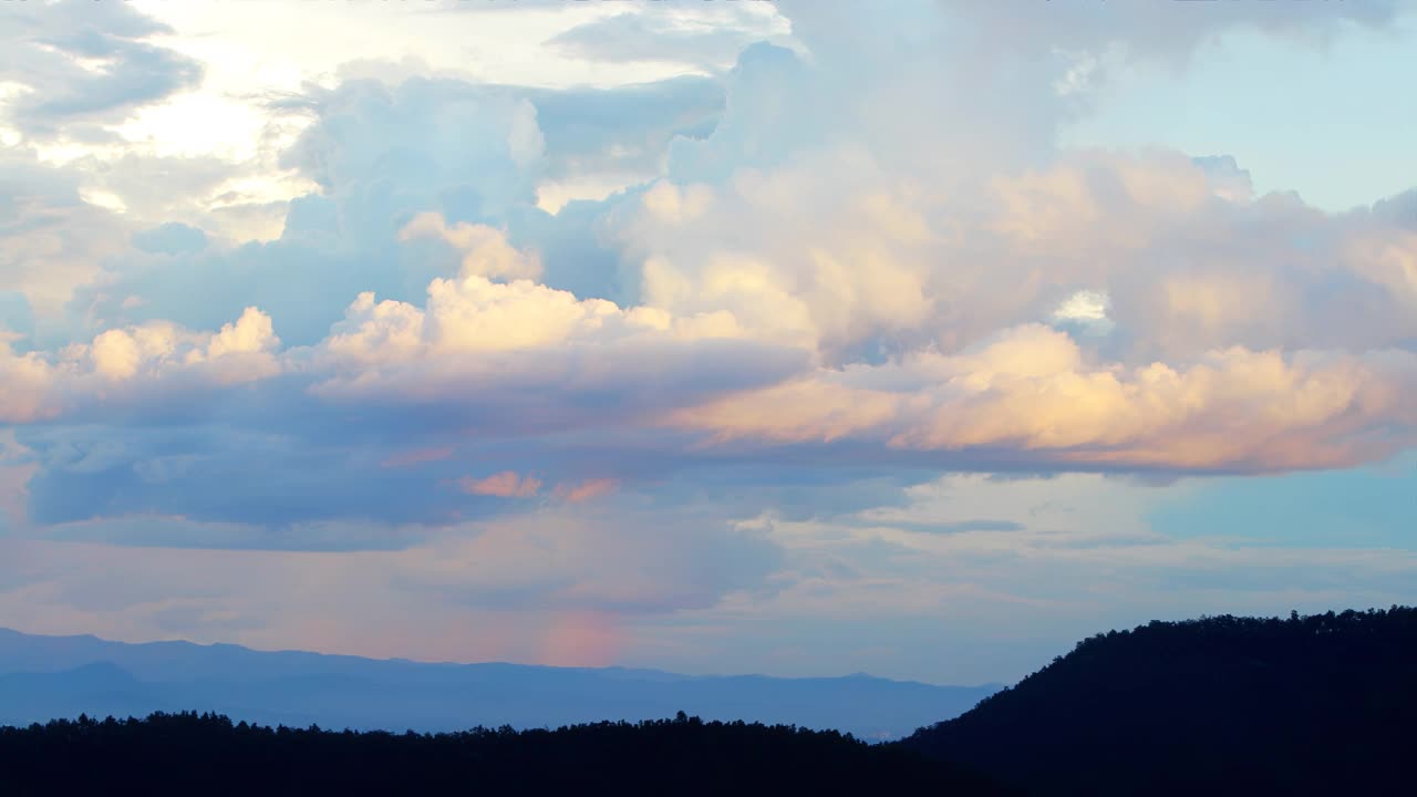 日落时分，神奇的蓝橙云在山上盘旋。时间的流逝，放松的天气戏剧性的美氛围背景视频下载