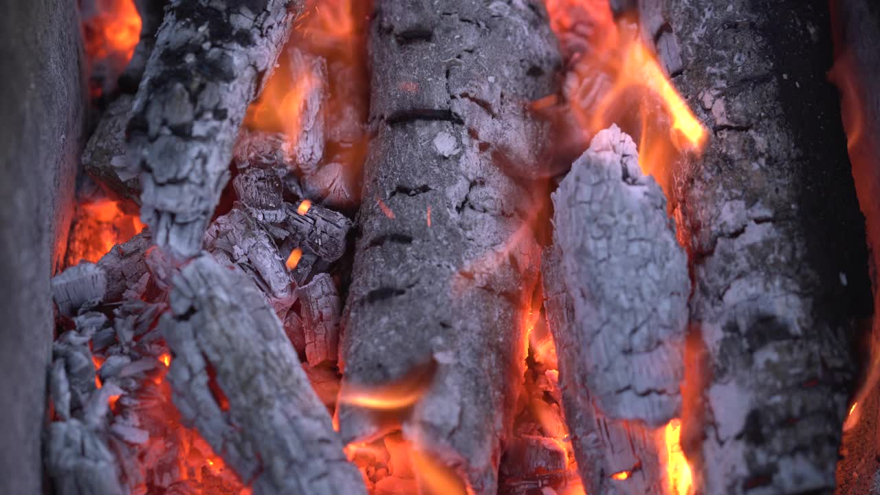 篝火的特写火焰，木头，煤炭，灰烬。夏天晚上烧烤用的火。美丽的自然视频4K。特写镜头篝火视频素材