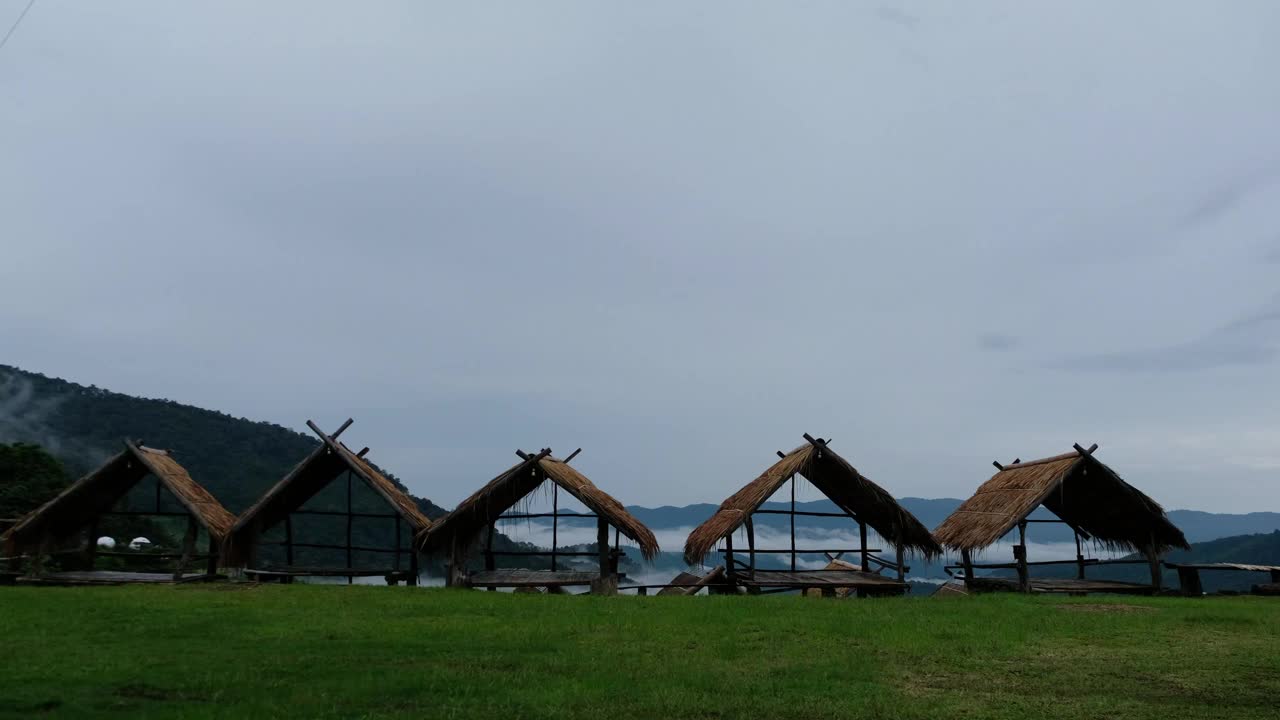 一位提着包的妇女走过山村的一间小屋视频素材