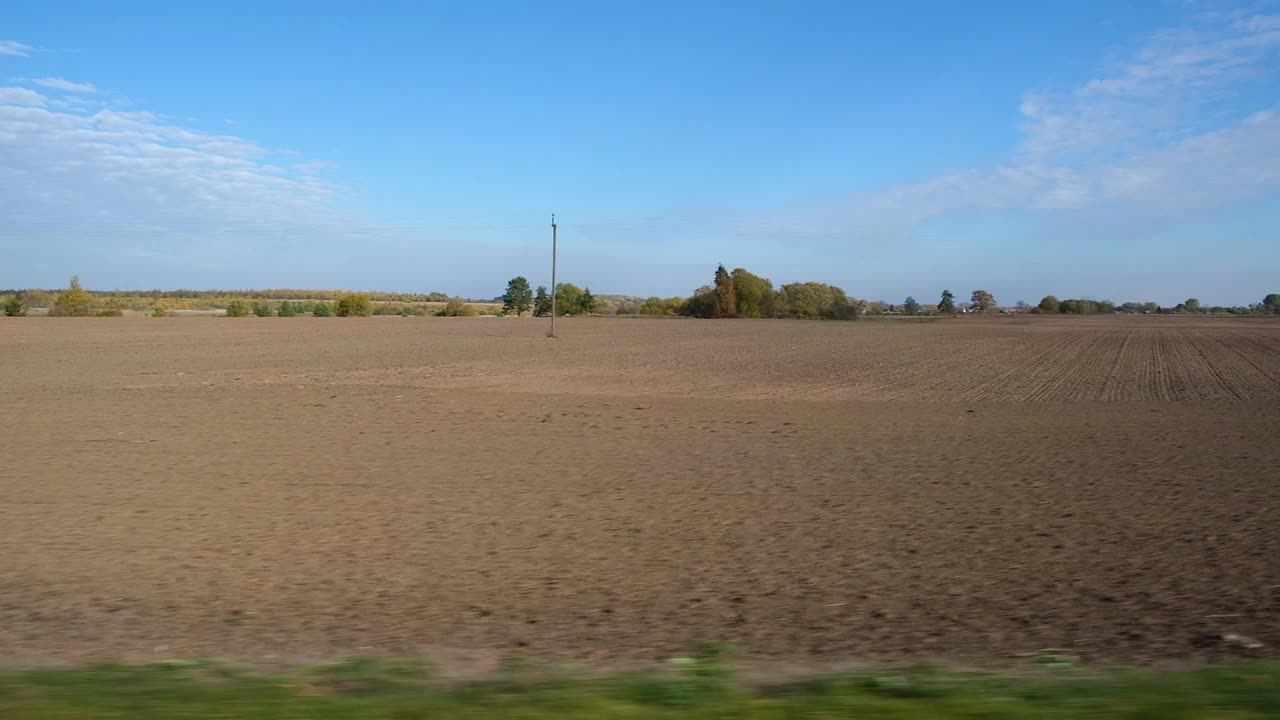 在穿过农田的路上超速行驶的汽车。通过汽车的侧窗在道路上运动。旅游与旅行，旅行与旅行的概念。美丽的秋天自然和风景。阳光明媚的天气。视频素材