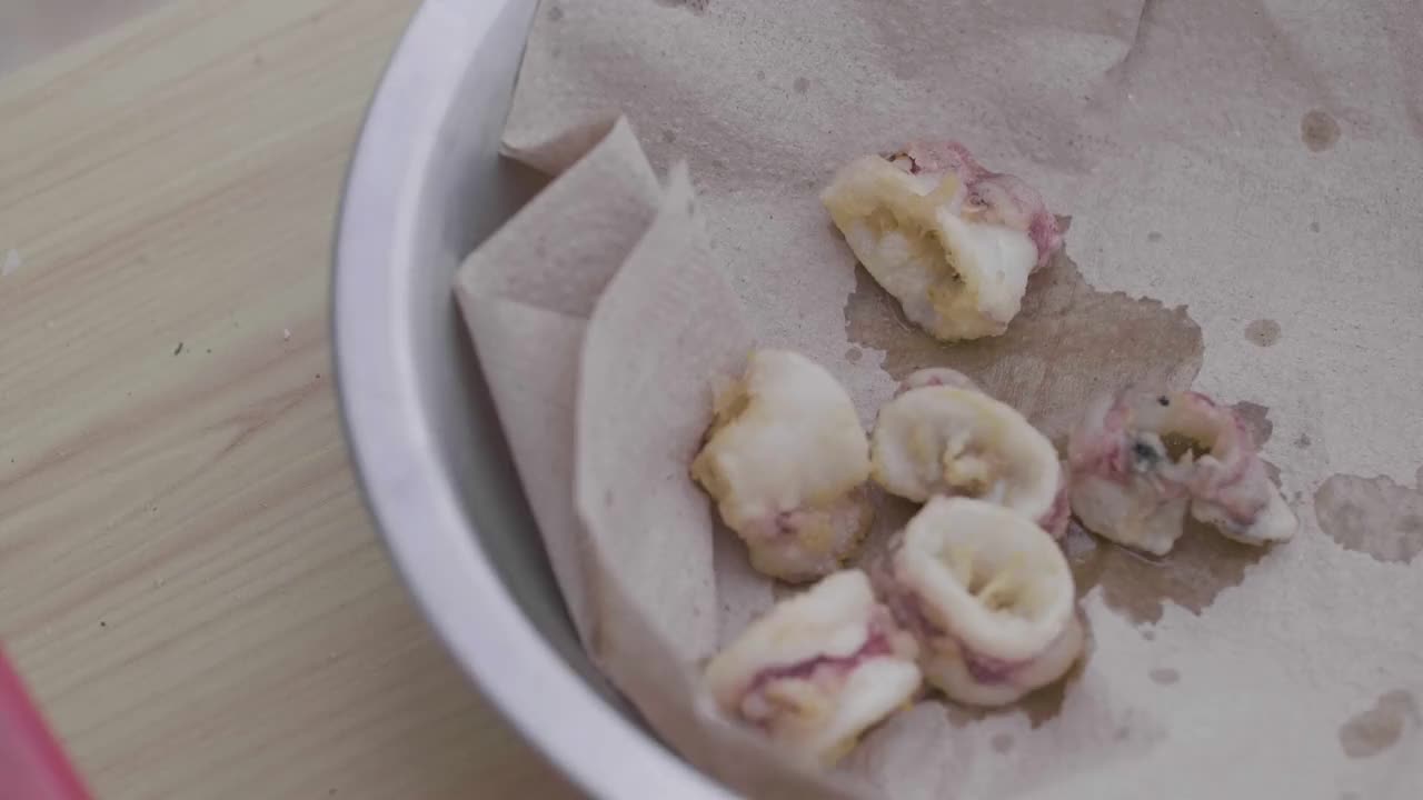 鱿鱼在烹饪纸上碗，烹饪油炸鱿鱼或鱿鱼特写视频素材