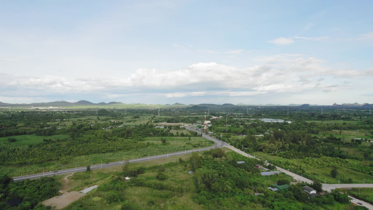 无人机拍摄:公路旅行。背景中有农田和丘陵。视频素材